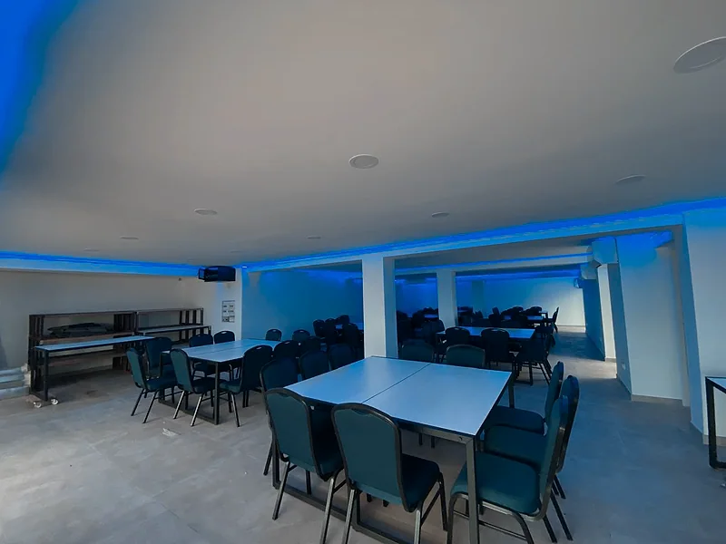 La salle installée en tables, en lumière de soirée