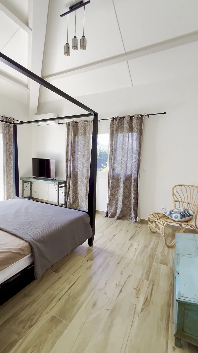 Une chambre de la villa avec son lit à baldaquin