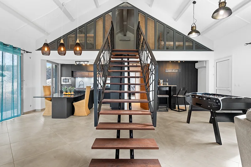 L'escalier en bois et métal de la villa, sous la charpente blanche